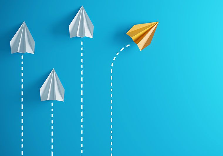Four paper airplanes with one veering off to the right