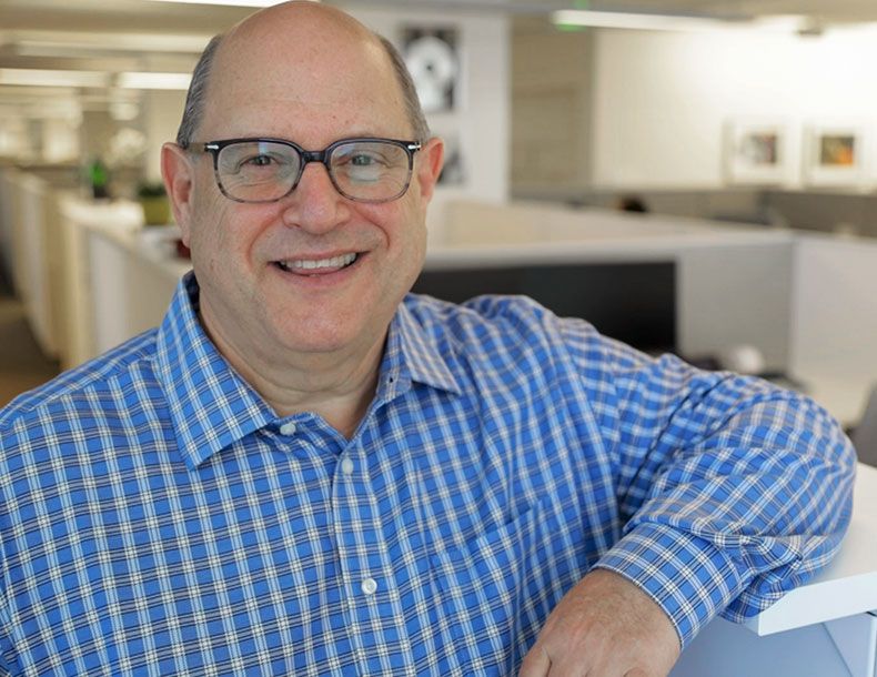 A man smiling at the camera in an office
