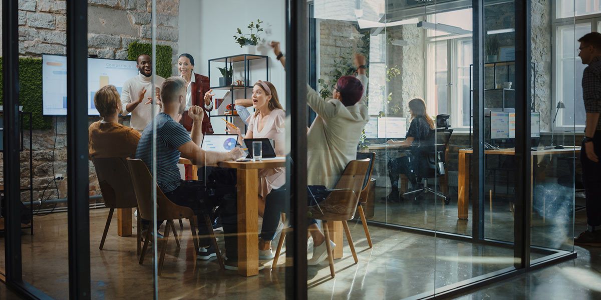 Team of people converse around an office table