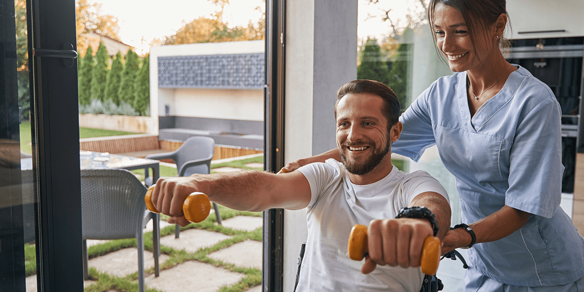 man in wheelchair doing physical therapy with caregiver