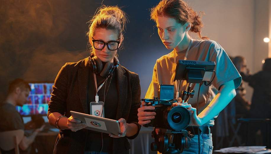Two members of a film crew looking at a tablet