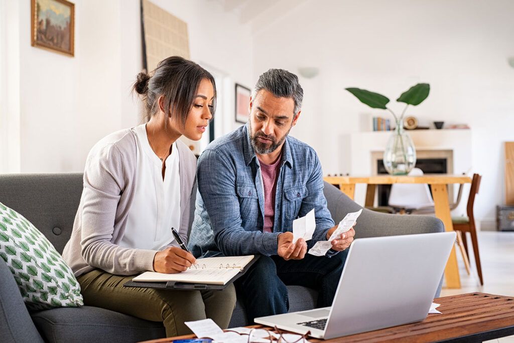 Couple sitting on a couch, reviewing documents together