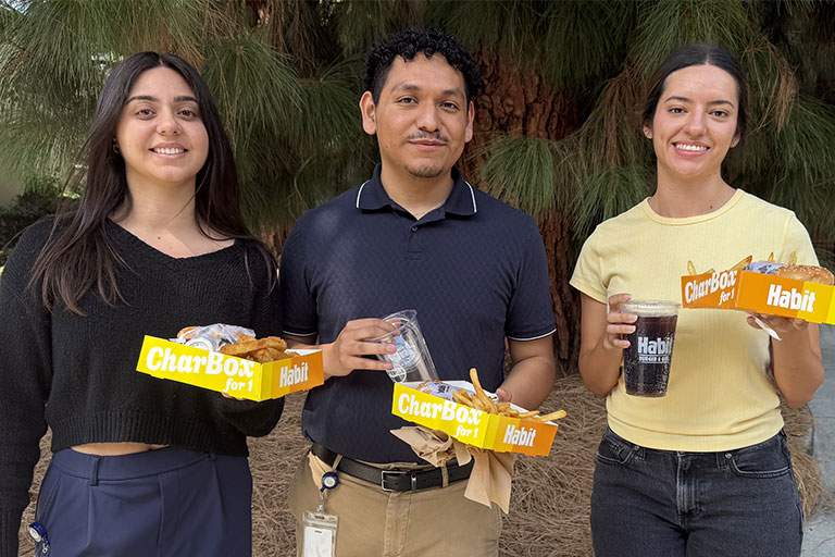 three people holding food